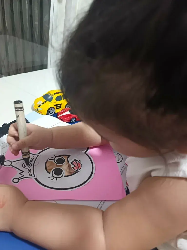 A student coloring carefully at the desk