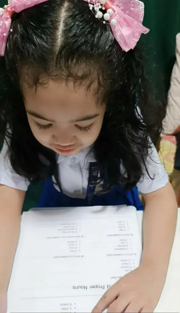 A student reading a common and proper nouns worksheet