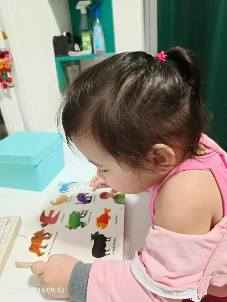 A student reading a picture book at the tutoring table